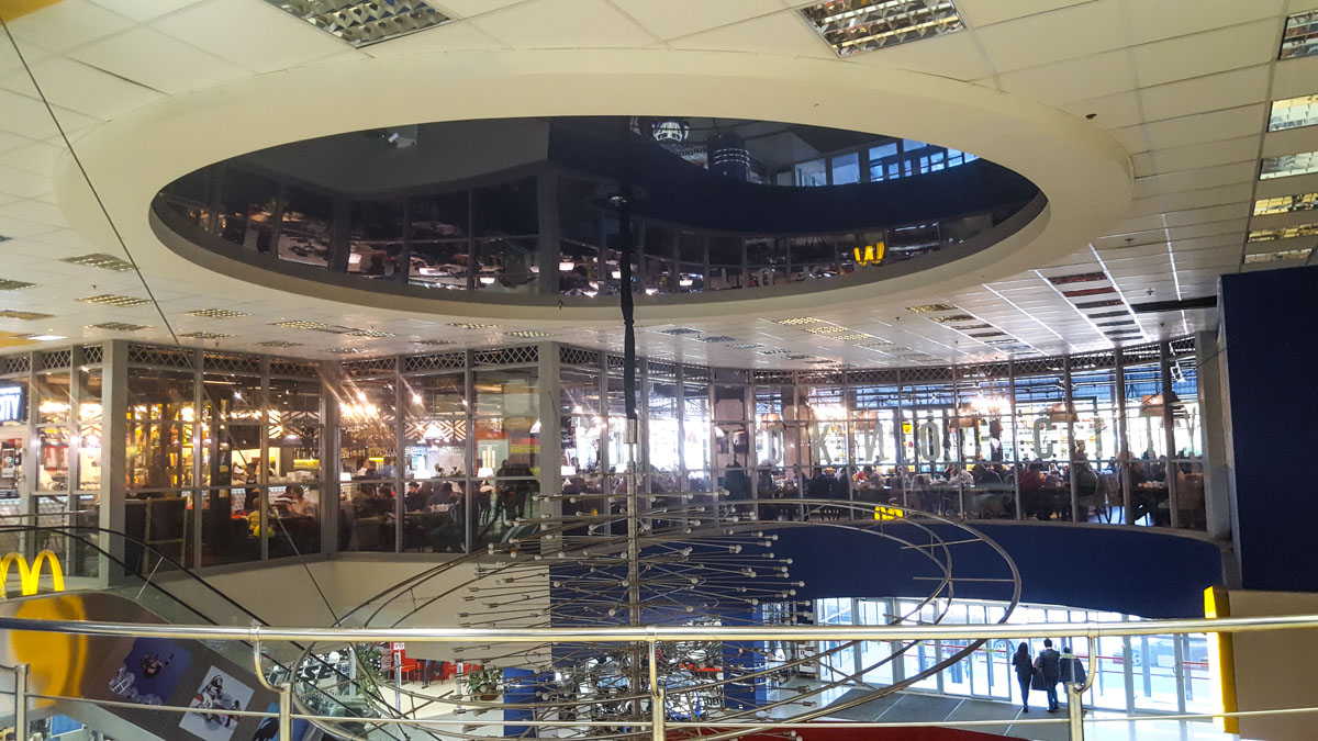 Натяжной потолок и большая люстра в холле торгового центра