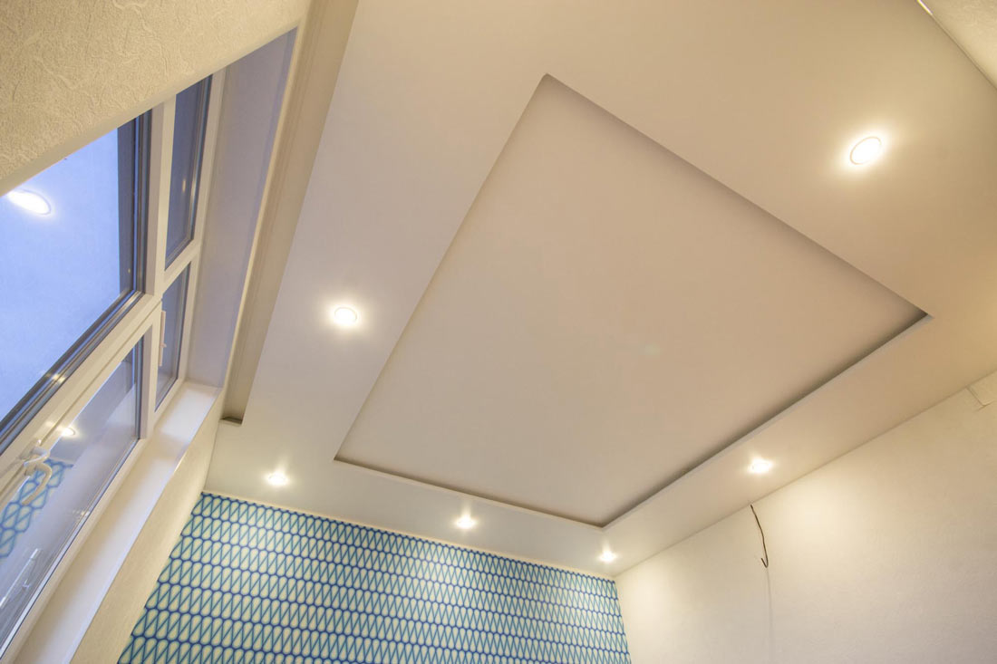 двухуровневый натяжной потолок с установленными светильниками вид от окна