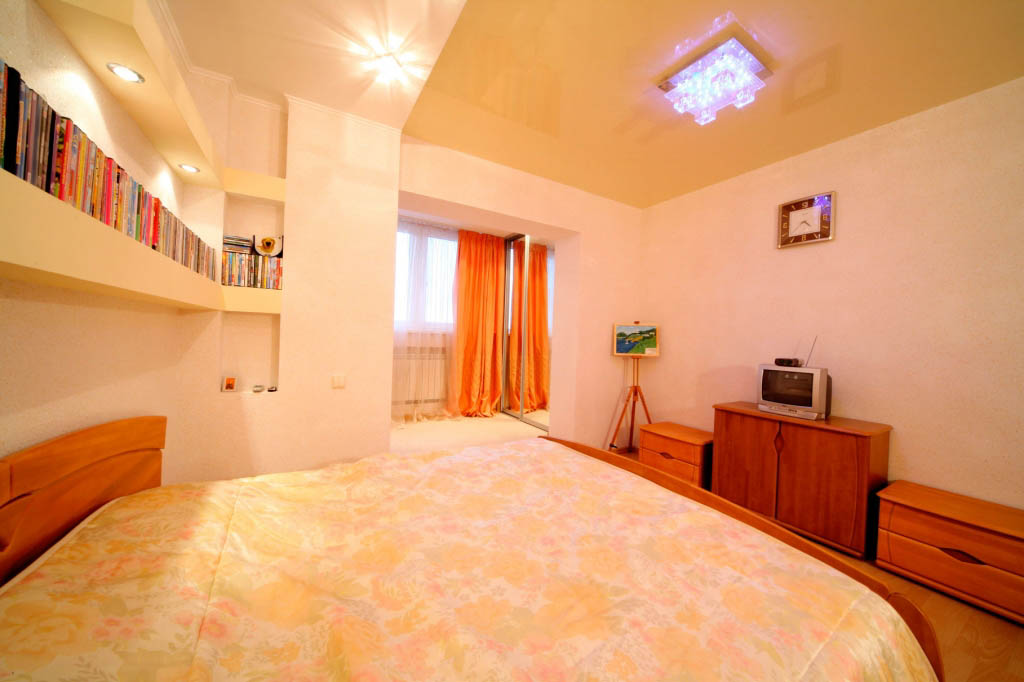 Глянцевый натяжной потолок: красивый интерьер в спальне по доступной цене